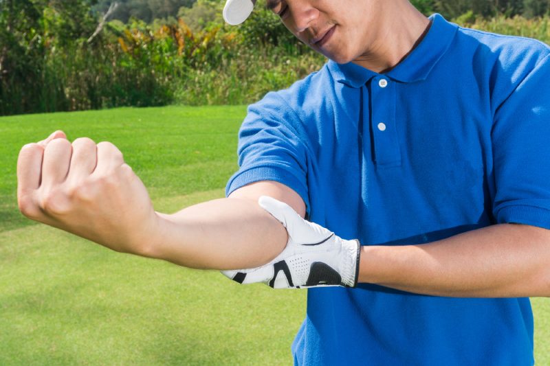 Golfer elbow pain during the game, muscle injury concept.